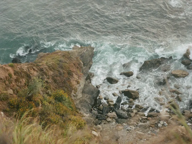 Surf breaking on a rocky coast seen from above