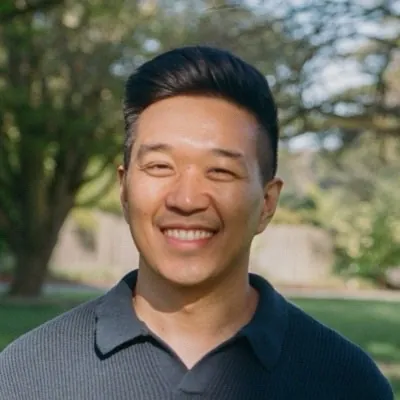 Andrew Tolentino smiling, inviting readers to book a free discovery call